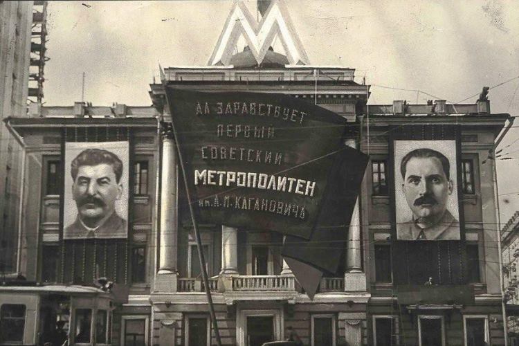כרזה של לזר קגנוביץ' (מימין) בתחנת מטרו במוסקבה באמצע המאה העשרים